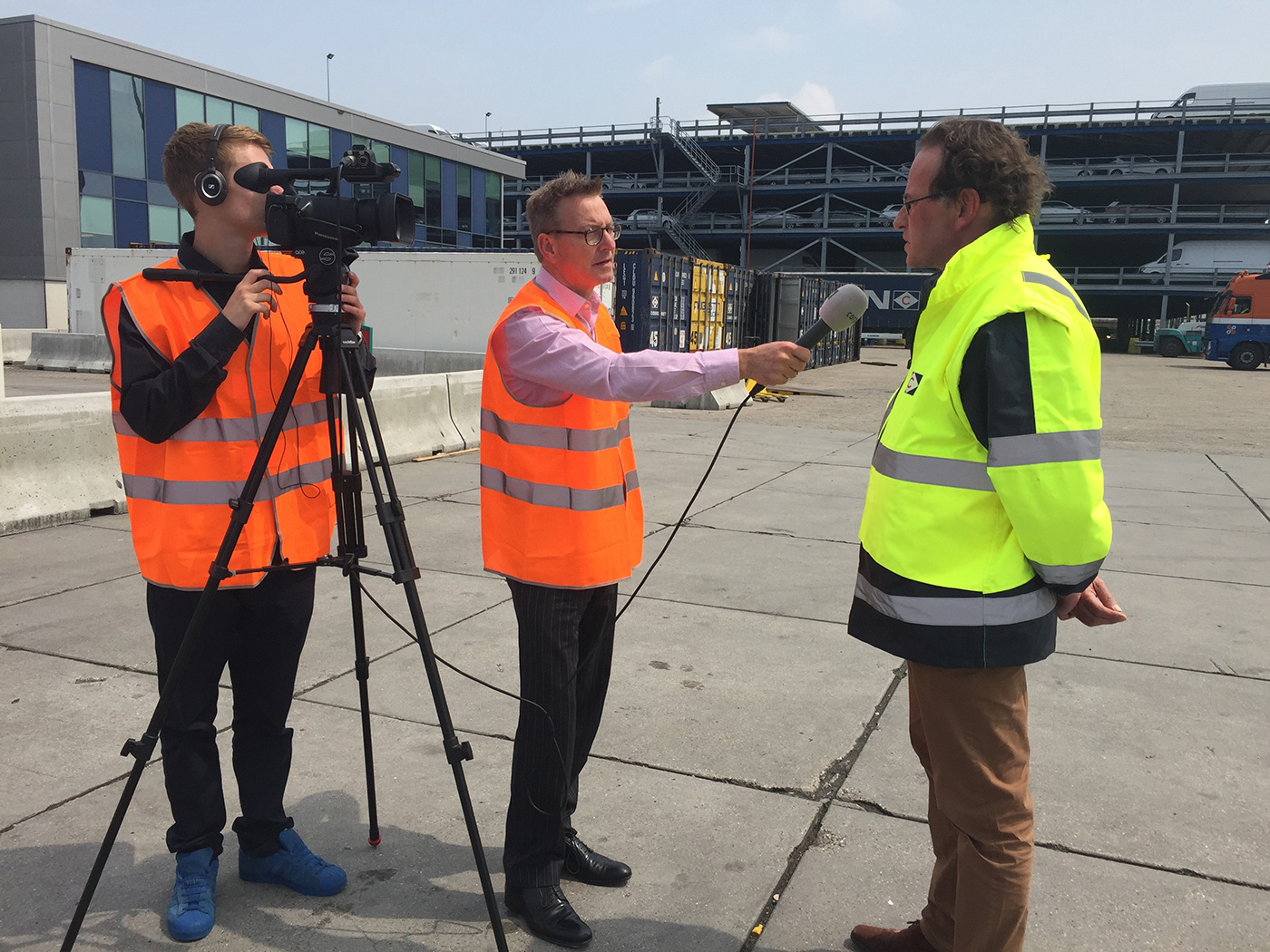 Crisis communication training. TV reporter questions spokesman on location at the Port of Rotterdam.