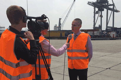 Training crisiscommunicatie. TV-verslaggever ondervraagt woordvoerder op locatie in de Rotterdamse haven.